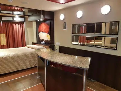 a room with a bed and a kitchen with a counter at Le Chabrol Hotel & Suites in Montréal