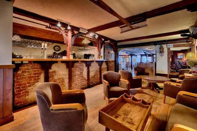 a room with a bar with chairs and a table at Auberge Handfield et Spa in Saint-Marc-sur-Richelieu