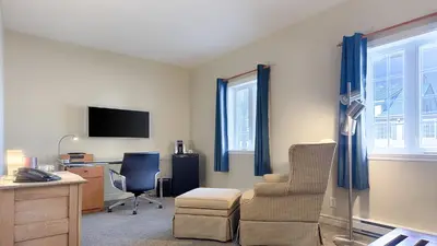 a living room with a desk and a chair at Auberge Handfield et Spa in Saint-Marc-sur-Richelieu