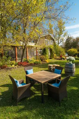 a wooden table and chairs in front of a house at Auberge West Brome in West Brome