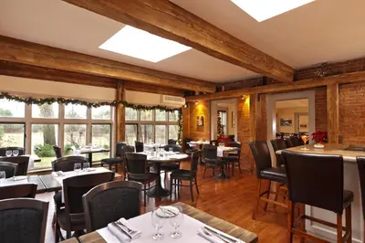 a dining room with tables and chairs and windows at Auberge West Brome in West Brome