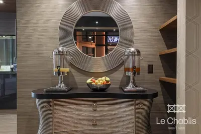 a counter with a bowl of fruit and a mirror at Hotel Le Chablis Cadillac in Montréal