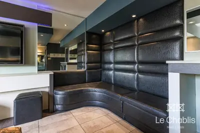 a bar with a black leather wall at Hotel Le Chablis Cadillac in Montréal