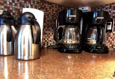 two coffee pots sitting on a counter next to a coffee maker at Accueil Chez Francois in Montréal
