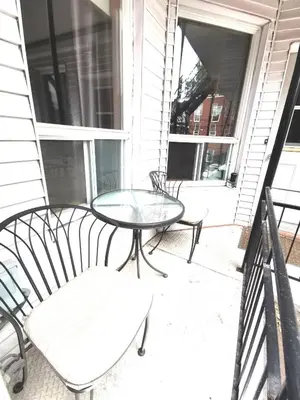a glass table and chairs on a porch at Accueil Chez Francois in Montréal