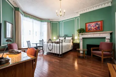 a living room with a bed and a fireplace at Hotel Chateau de l'Argoat in Montréal