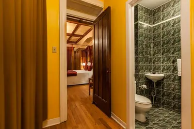 a bathroom with yellow walls and a toilet and a sink at Hotel Chateau de l'Argoat in Montréal