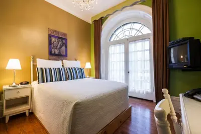 a bedroom with a bed and a tv and a window at Hotel Chateau de l'Argoat in Montréal
