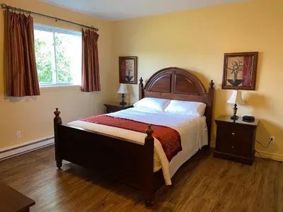 a bedroom with a large bed and a window at Motel le Phare in Plessisville