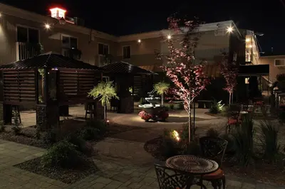 a courtyard at night with a building with lights at Motel le Phare in Plessisville