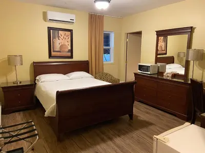 a hotel room with a bed and a mirror at Motel le Phare in Plessisville