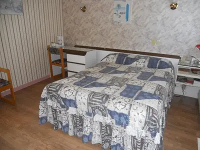 a bedroom with a bed with a blue and white quilt at Motel Normandie in Louiseville