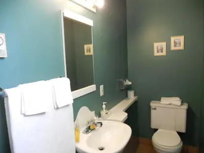 a bathroom with a white toilet and a sink at Motel Normandie in Louiseville
