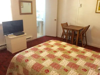 a bedroom with a bed and a table with a television at Motel Saint-Hilaire in Mont-Saint-Hilaire