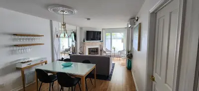 a kitchen and living room with a table and chairs at Location Tourisme Estrie - Oberge du Village in Magog-Orford