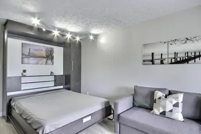 a bedroom with a bed and a couch at Location Tourisme Estrie - Oberge du Village in Magog-Orford