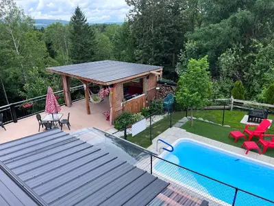 a house with a gazebo and a swimming pool at Le Loft Riverstone CITQ 3O1849 in Saint Pierre de Broughton