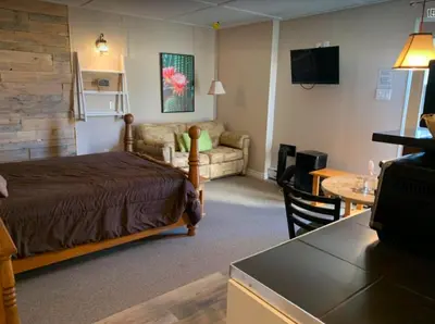 a hotel room with a bed and a living room at Le Loft Riverstone CITQ 3O1849 in Saint Pierre de Broughton