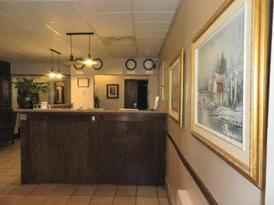 a bar in a waiting room with pictures on the wall at L'Auberge de l'Aeroport Inn in Dorval