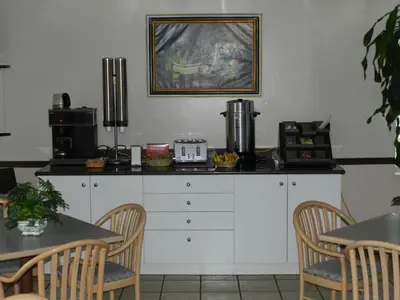 a kitchen with a counter with chairs and a table at L'Auberge de l'Aeroport Inn in Dorval