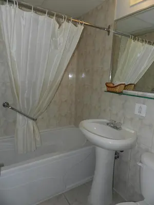 a bathroom with a sink and a tub and a toilet at L'Auberge de l'Aeroport Inn in Dorval
