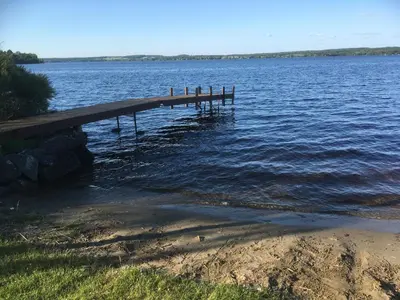 a dock in the water next to a body of water at La Grange sur le Lac App A et B in Saint Romain