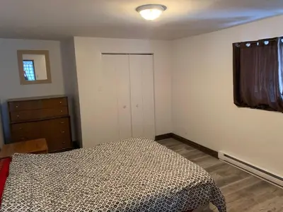 a bedroom with a bed and a dresser and a window at La Grange sur le Lac App A et B in Saint Romain