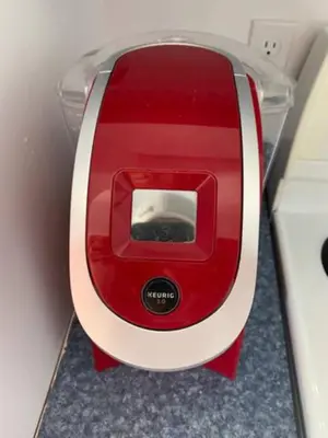 a red and white toaster sitting on a counter at La Grange sur le Lac App A et B in Saint Romain