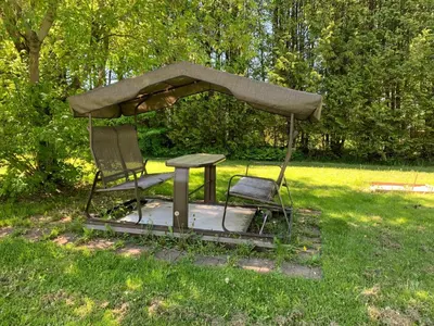 two chairs and a table with an umbrella in the grass at La Grange sur le Lac App A et B in Saint Romain