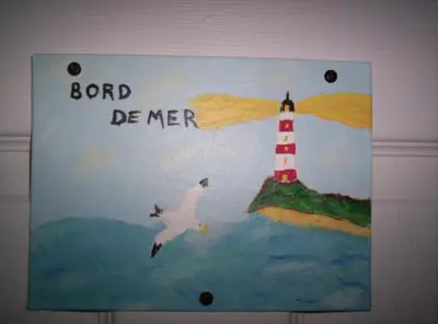 a board with a lighthouse and two seagulls at Gîte Au p'tit bonheur B&B in Coaticook