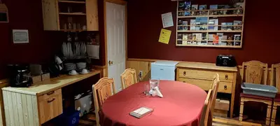 a kitchen with a red table and chairs and a counter at Gîte Au p'tit bonheur B&B in Coaticook