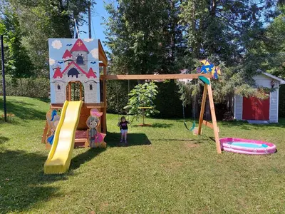 a child is standing in front of a play house at Gîte Au p'tit bonheur B&B in Coaticook