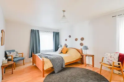a bedroom with a bed and a chair at L'Auberge du QG in Laprairie