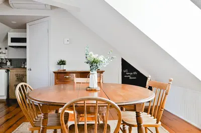a dining room with a wooden table and chairs at L'Auberge du QG in Laprairie