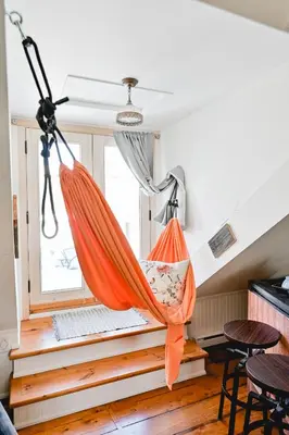 an orange hammock in a room with a window at L'Auberge du QG in Laprairie