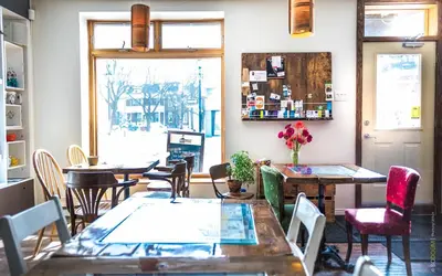 a restaurant with tables and chairs and a window at L'Auberge du QG in Laprairie