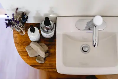 a bathroom counter with a sink and two towels at L'Auberge du QG in Laprairie