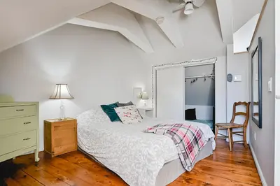 a bedroom with a bed and a dresser and a mirror at L'Auberge du QG in Laprairie