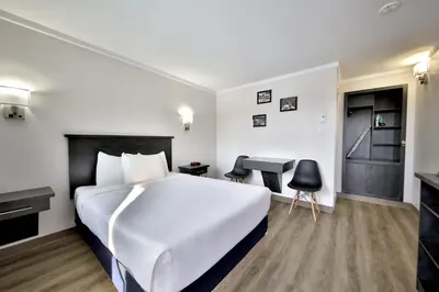 a hotel room with a bed and a desk at Motel Newstar Laval in Laval