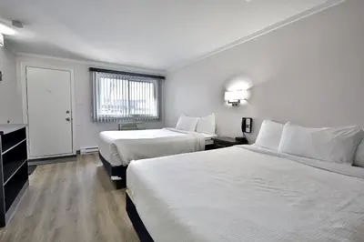 a hotel room with two beds and a window at Motel Newstar Laval in Laval