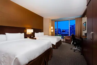 a hotel room with two beds and a desk and a window at Courtyard par Marriott Montréal Centre-ville in Montréal