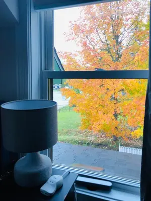 a lamp sitting on a desk in front of a window at Le « Lake View » de la Suite North Hatley in North Hatley