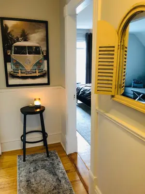 a hallway with a table and a picture of a van on the wall at Le « Lake View » de la Suite North Hatley in North Hatley
