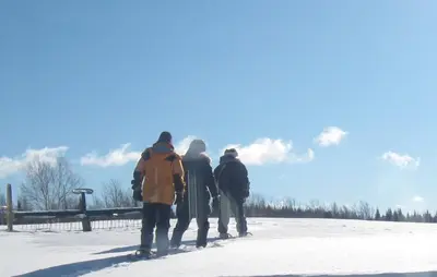 a group of three people walking in the snow at Domaine Montauban in Saint Fortunat