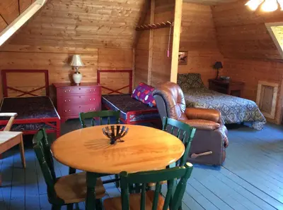 a room with a table and a bed in a cabin at Domaine Montauban in Saint Fortunat