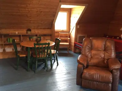a living room with a table and a leather chair at Domaine Montauban in Saint Fortunat
