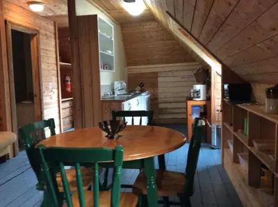 a dining room with a table and chairs in a cabin at Domaine Montauban in Saint Fortunat