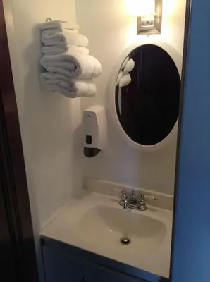 a bathroom with a sink and a mirror and towels at Le 100 St-Laurent in Louiseville
