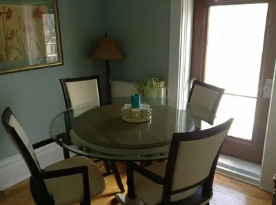 a dining room with a glass table and chairs at Le 100 St-Laurent in Louiseville