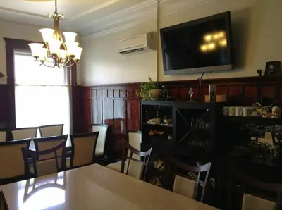 a dining room with a table and a television on a wall at Le 100 St-Laurent in Louiseville